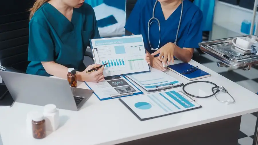 Home health SEO audit displayed on computer. Illustrated by 2 Health care professionals